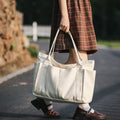 White large canvas tote bag carried by the handles