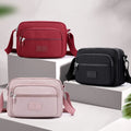 Brick red, black, and light pink four-zip crossbody bag color options