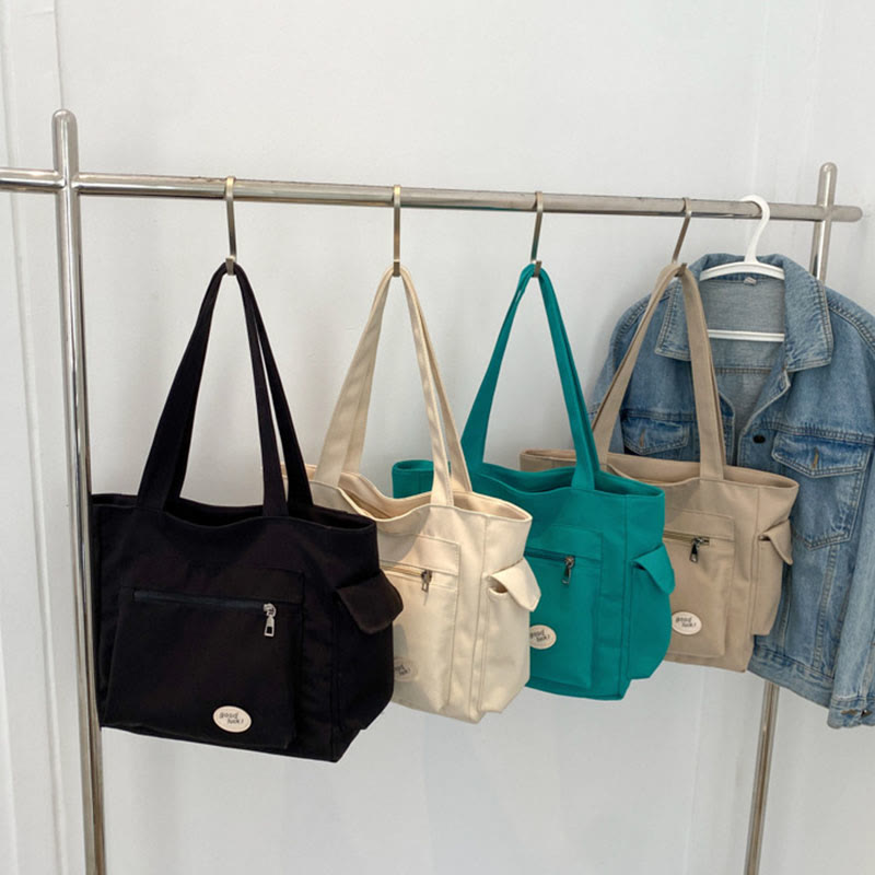 Black, ivory, mint green, and tan canvas tote color options