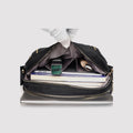 Black waterproof nylon crossbody bag organized with tablet, phone, and small essentials