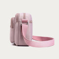 Light pink four-zip crossbody bag side view with adjustable strap