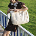 White large canvas tote bag worn on the shoulder