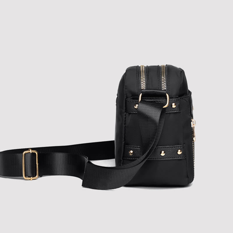 Black waterproof nylon crossbody bag side view and strap attachment