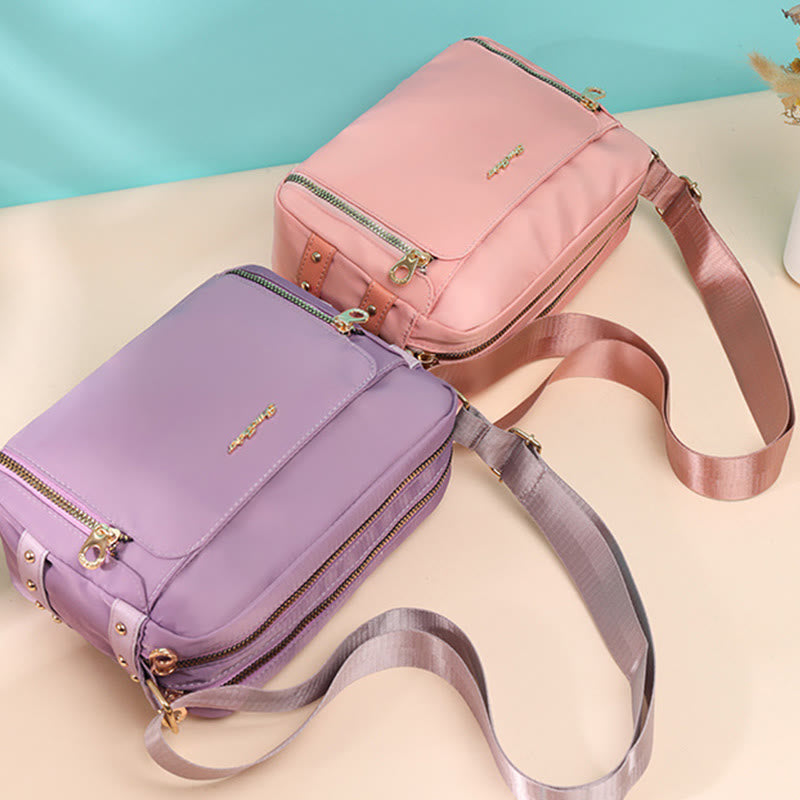 Light pink and plum waterproof nylon crossbody bags side by side