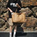 Beige large canvas tote bag carried by the handles